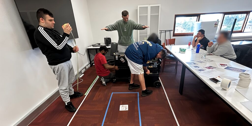 Wallara clients acting out a scenario in a space marked out on the ground representing the Makervan.