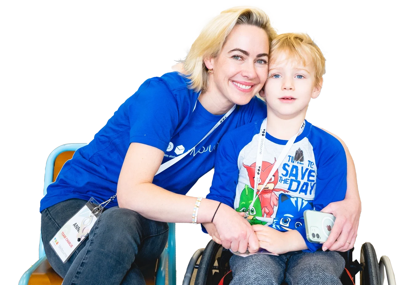 A boy and a woman leaning towards each other and looking to the camera.