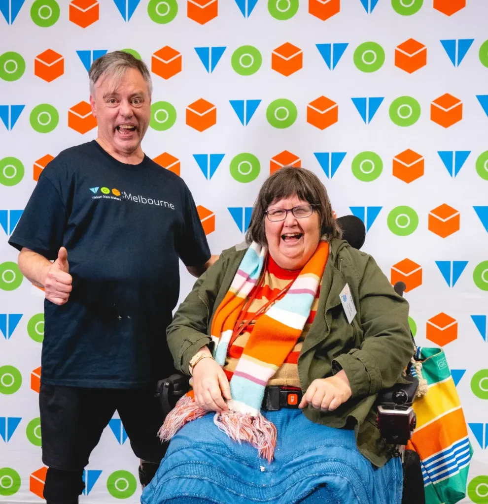 Two people smiling brightly to the camera.
