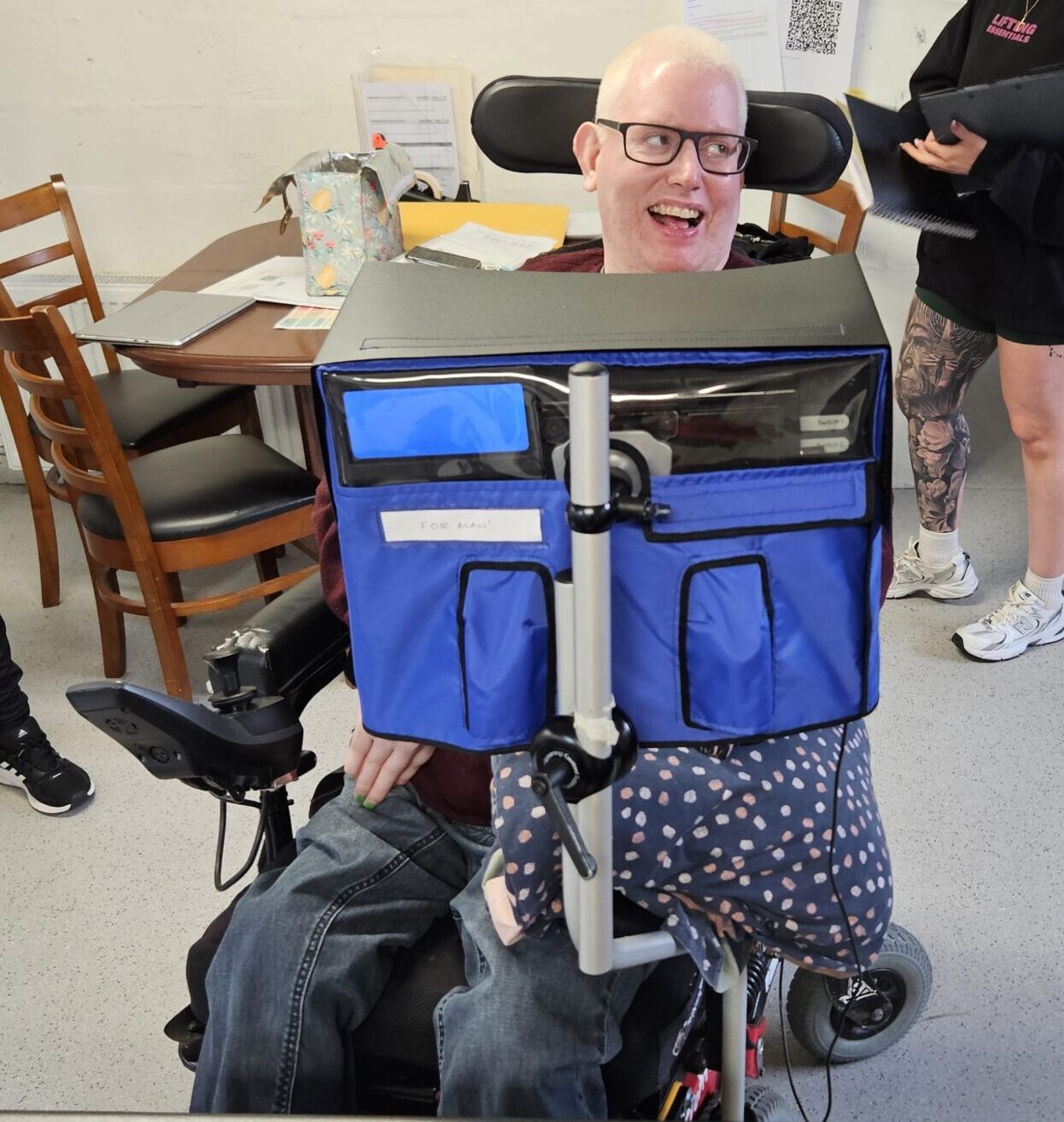 Man looking to the right and smiling behind his communication device.