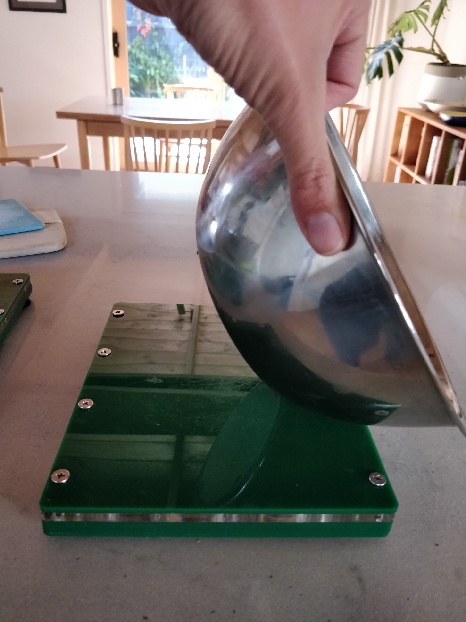 Stainless steel bowl on a green magnetic board.