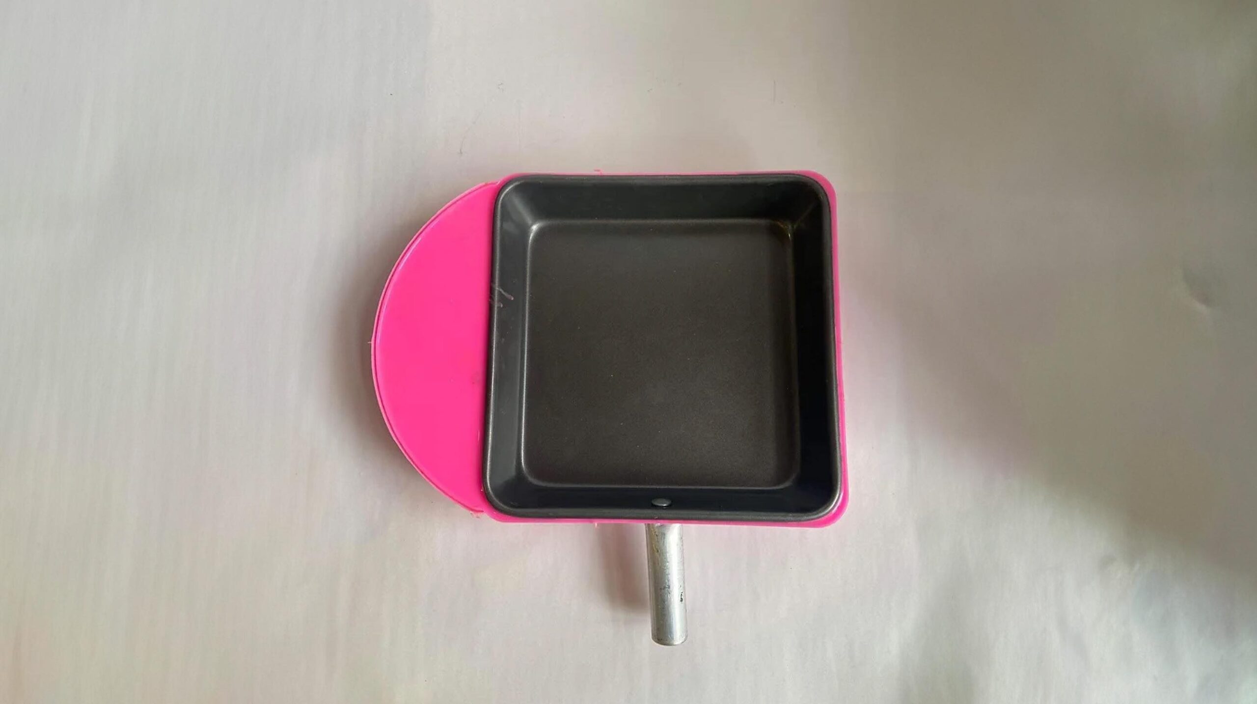 Teflon oven tray with pink silicon cover.