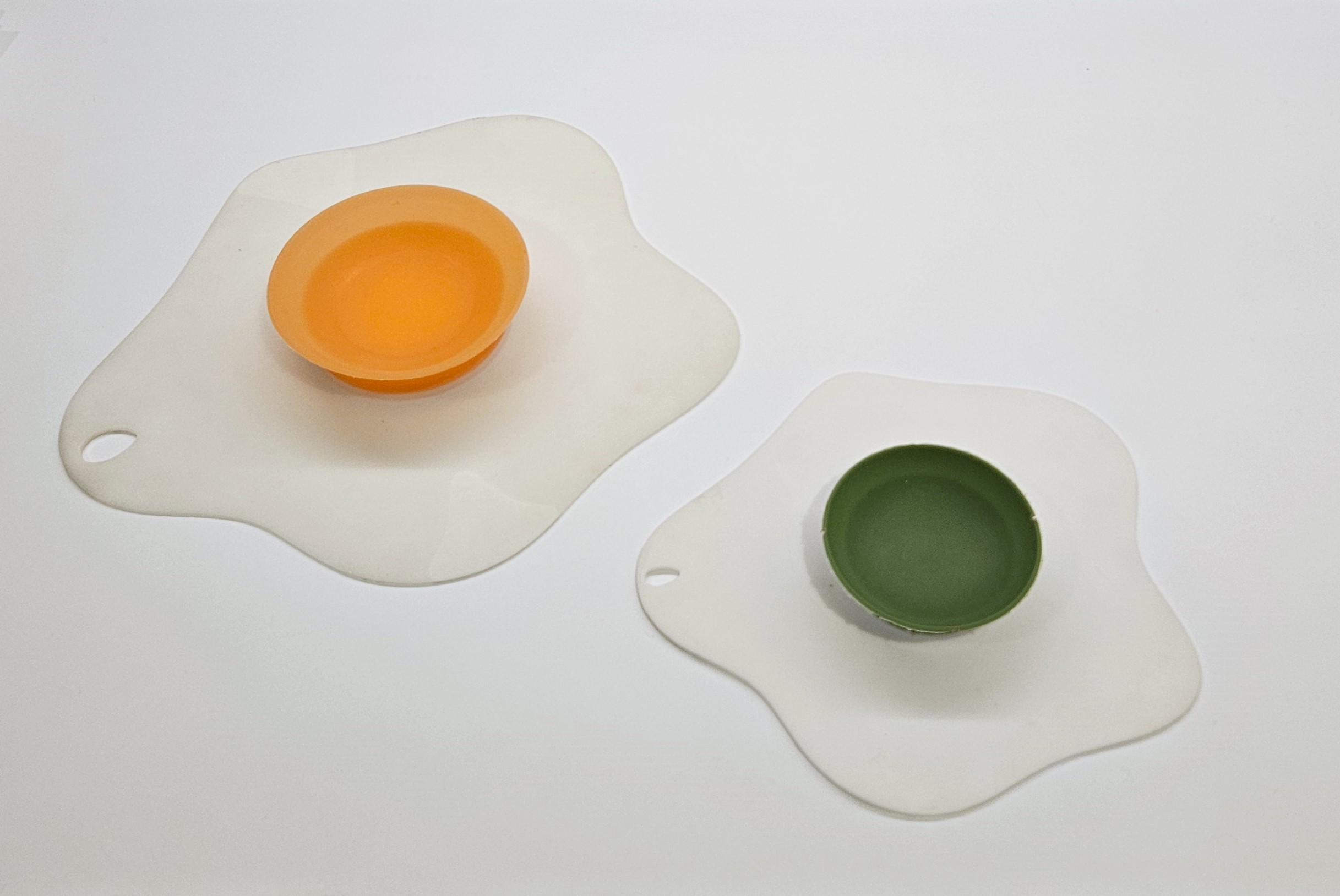 Two silicon bowl stabilisers in the shape of cracked eggs.