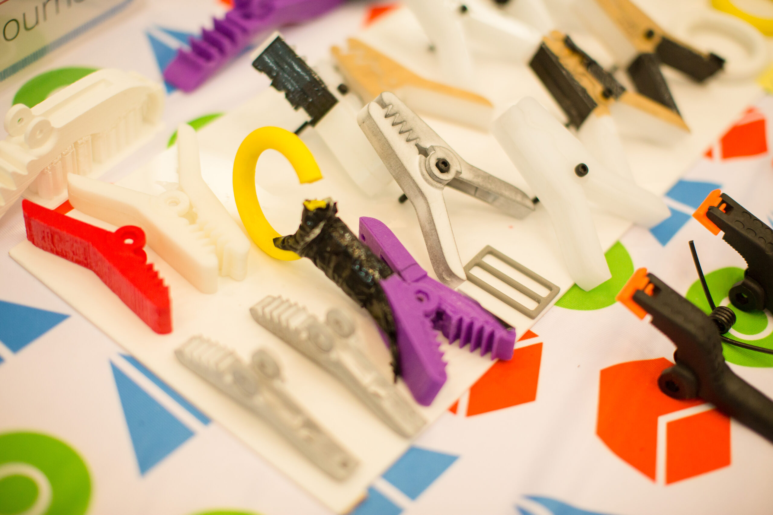 Different types of clamps in different colours spread on a TOM tablecloth.