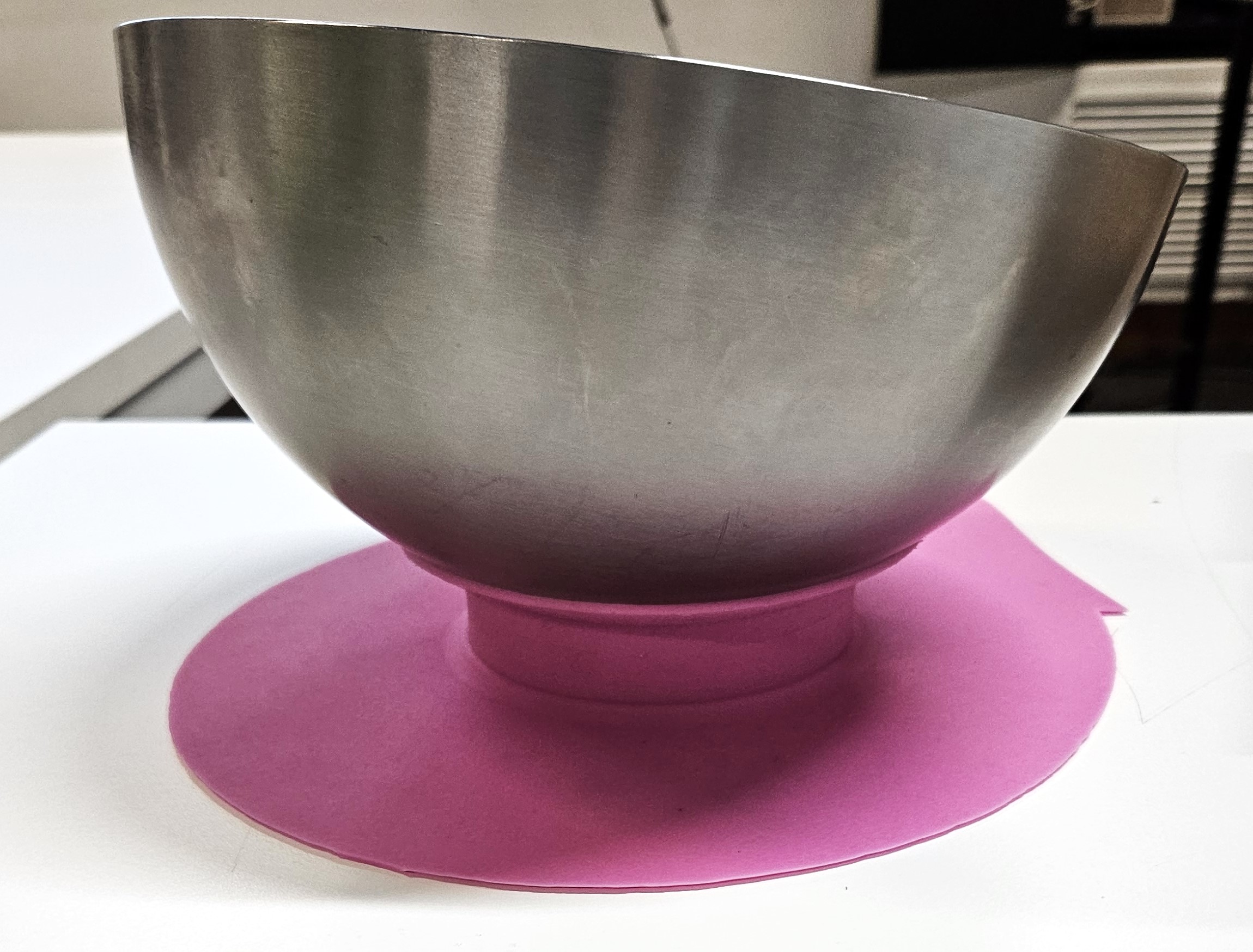 A stainless steel bowl in a pink bowl stabiliser.