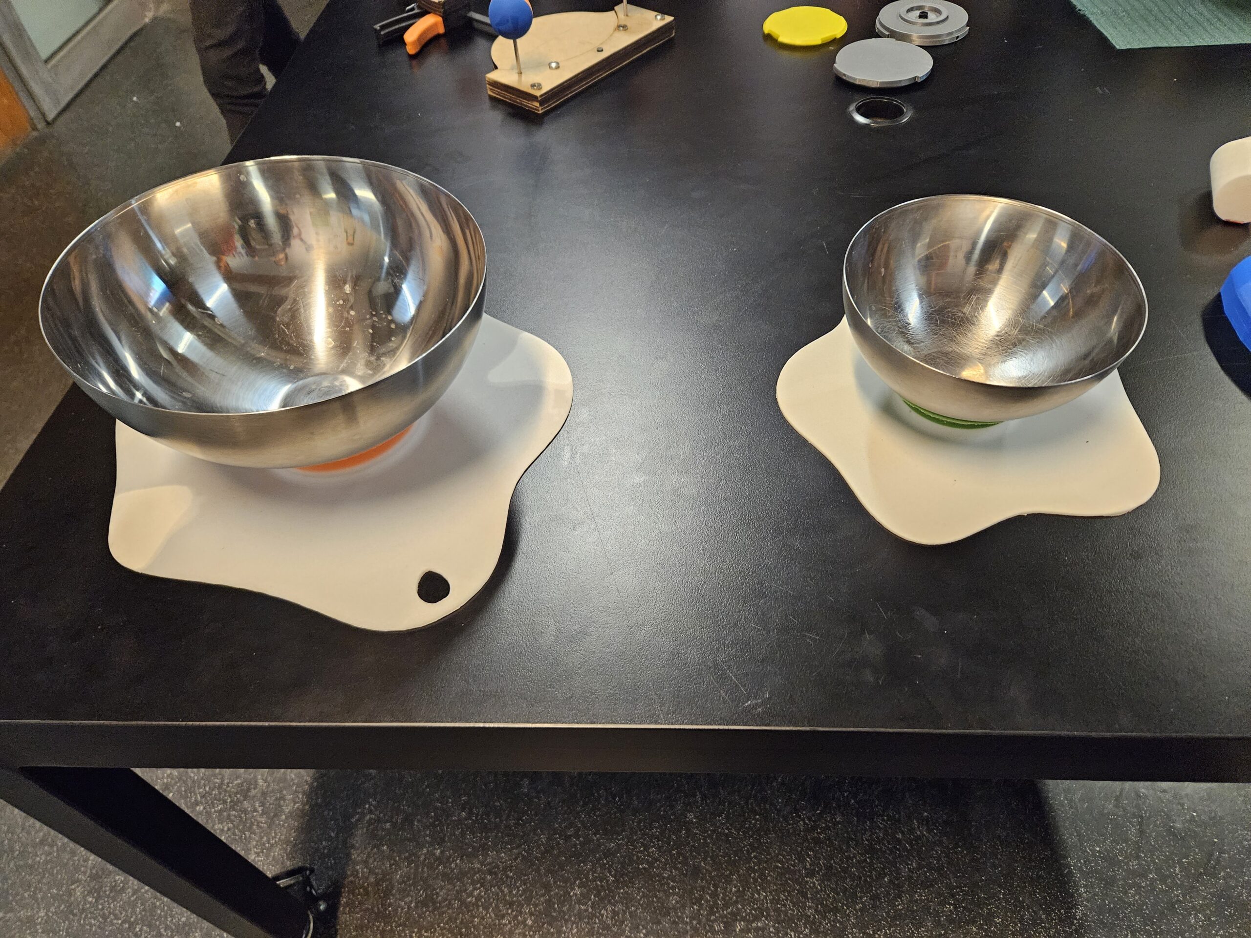 Two stainless steel bowls in bowl stabilisers.