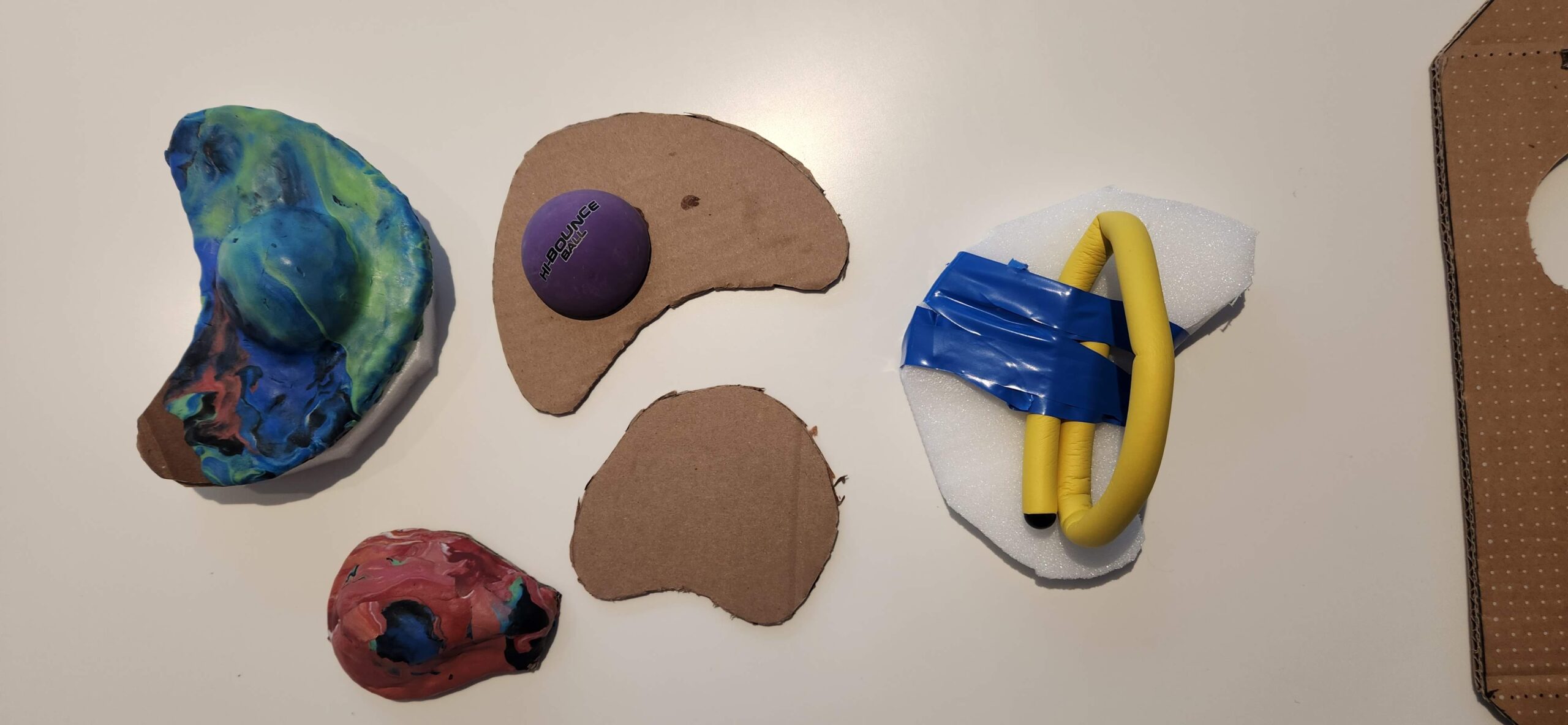 A range of cardboard and foam prototypes displayed on a table.