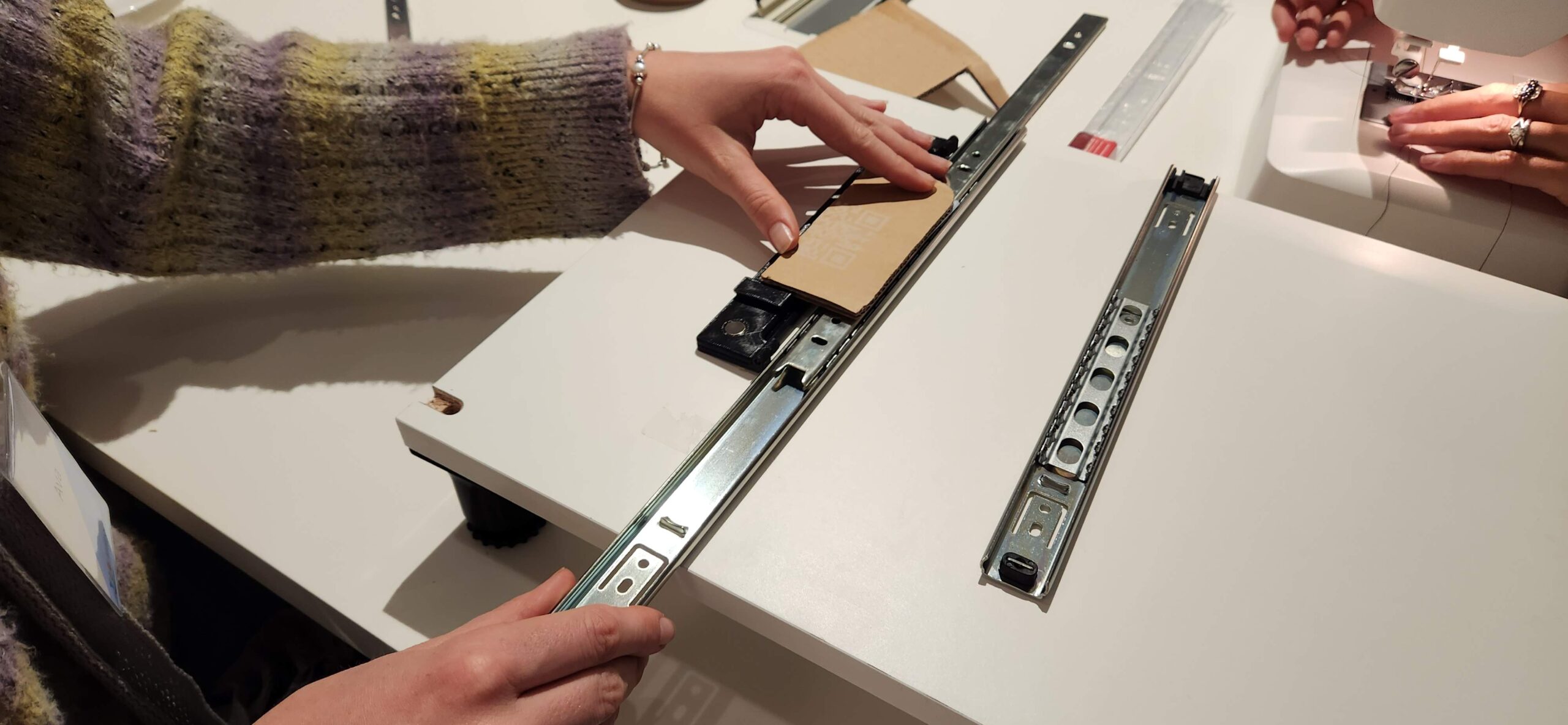 Hands holding an exposed drawer slide.