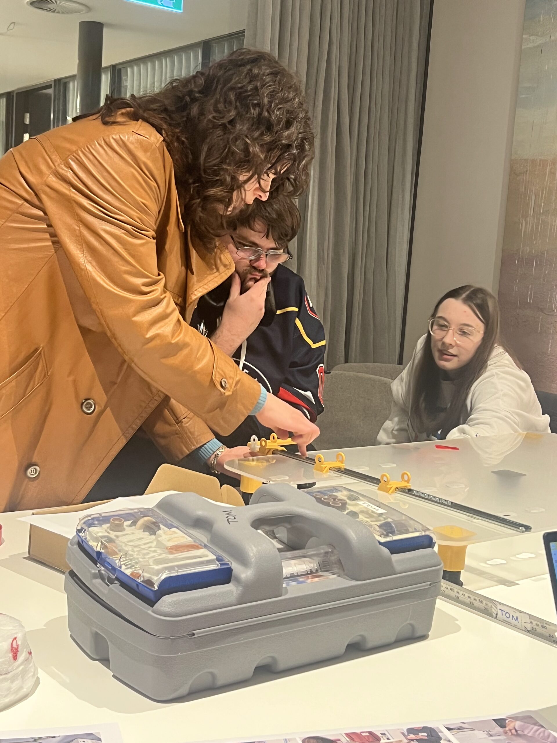 Group of makers sitting around a prototype.