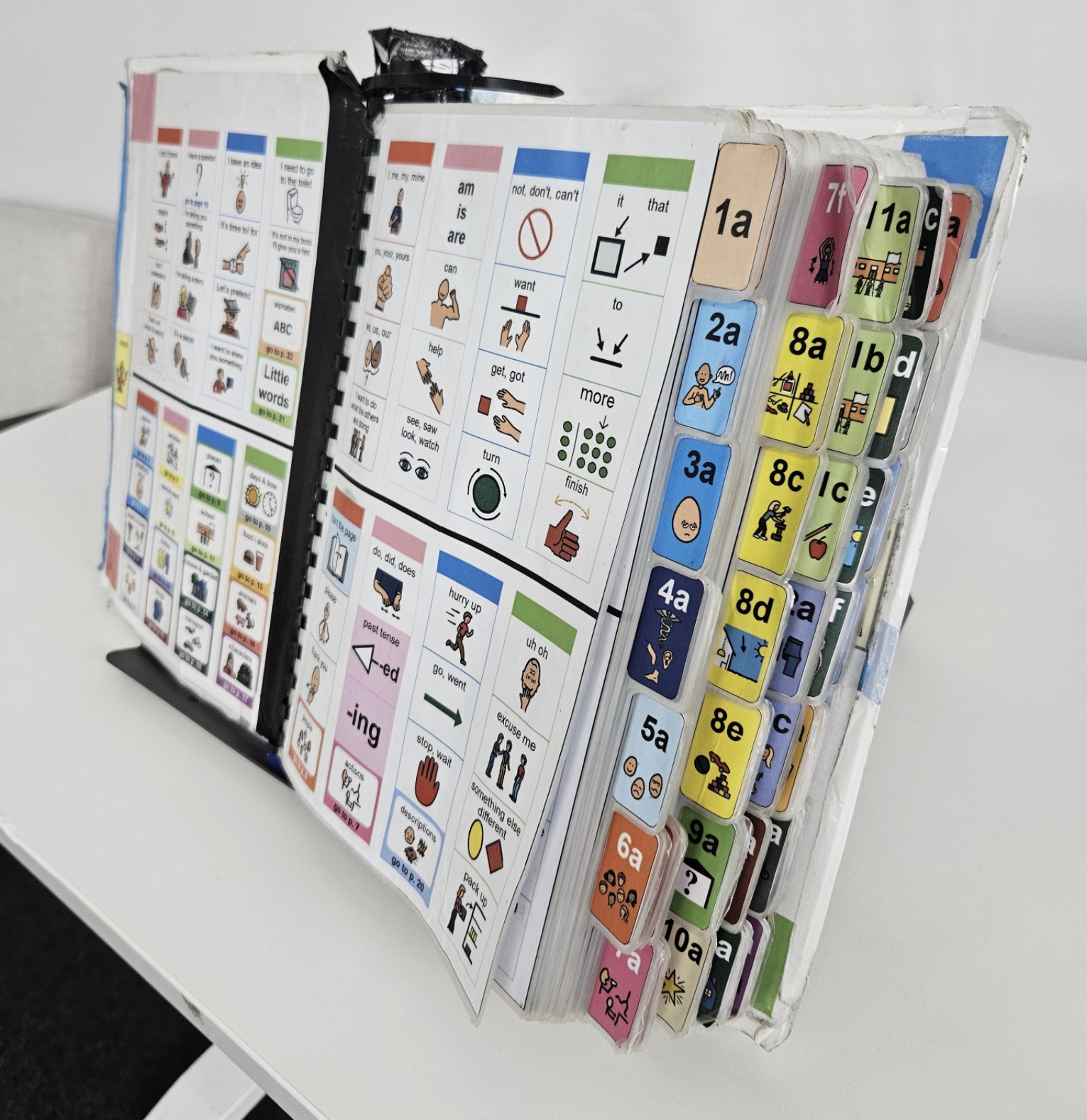 PODD book open to the centre and displaying colourful graphic icons and words