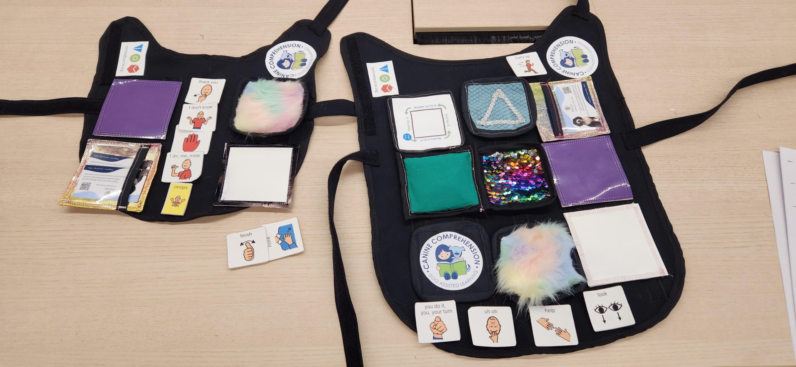 Two dog vests with a range of sensory elements attached with velcro.