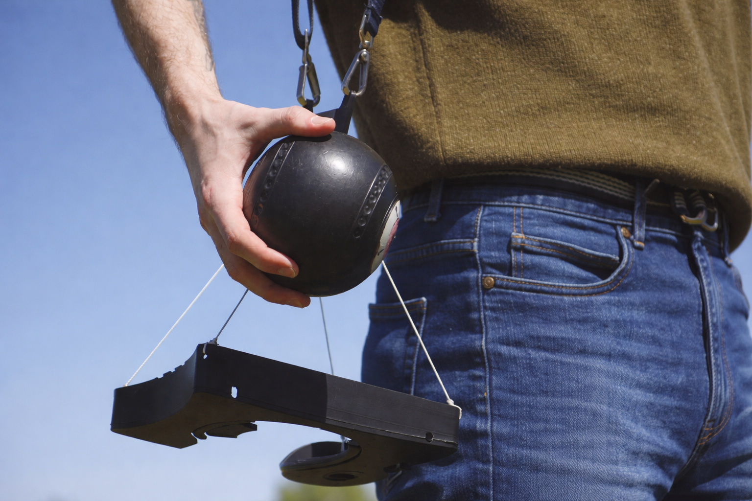 A close up view of the lawn bowl aid with a person holding a lawn bowl